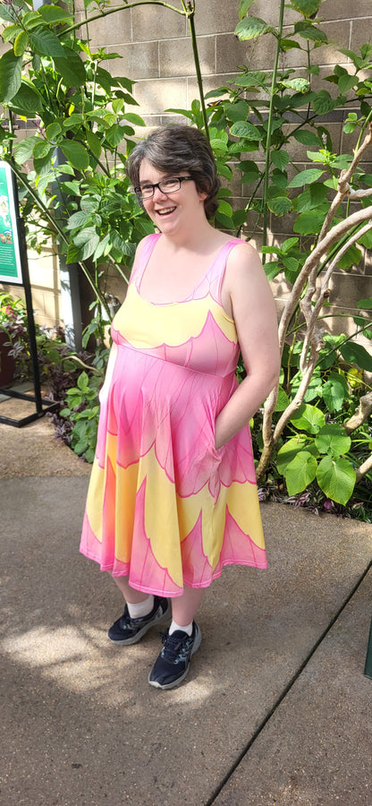 Person wearing a colorful dress standing outdoors with plants in the background