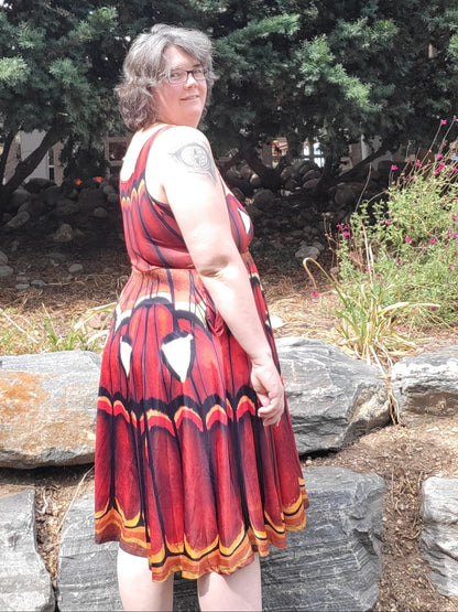 Atlas Moth dress in russet with vibrant butterfly wing pattern, sleeveless design, and flowing knee-length polyester fabric.